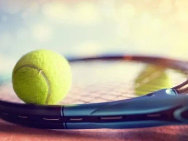 A tennis racket and ball on the court