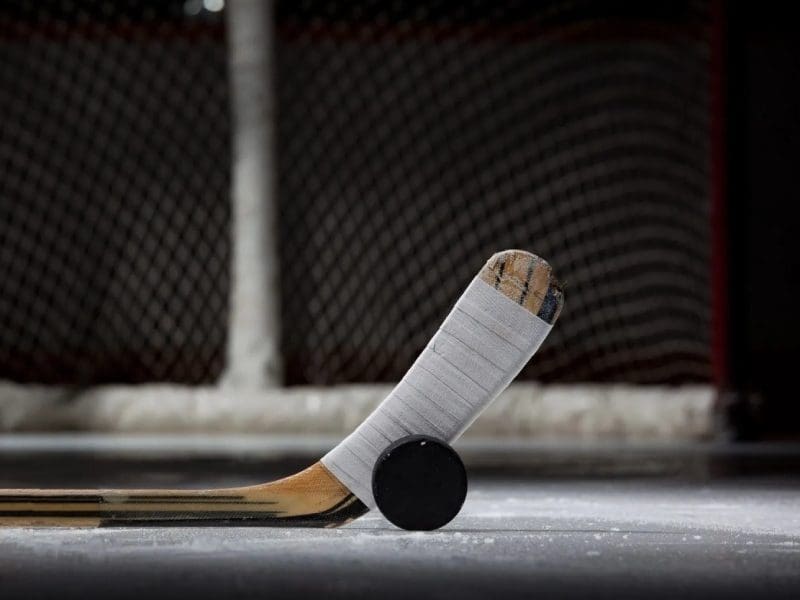 A hockey stick and puck on the ice.